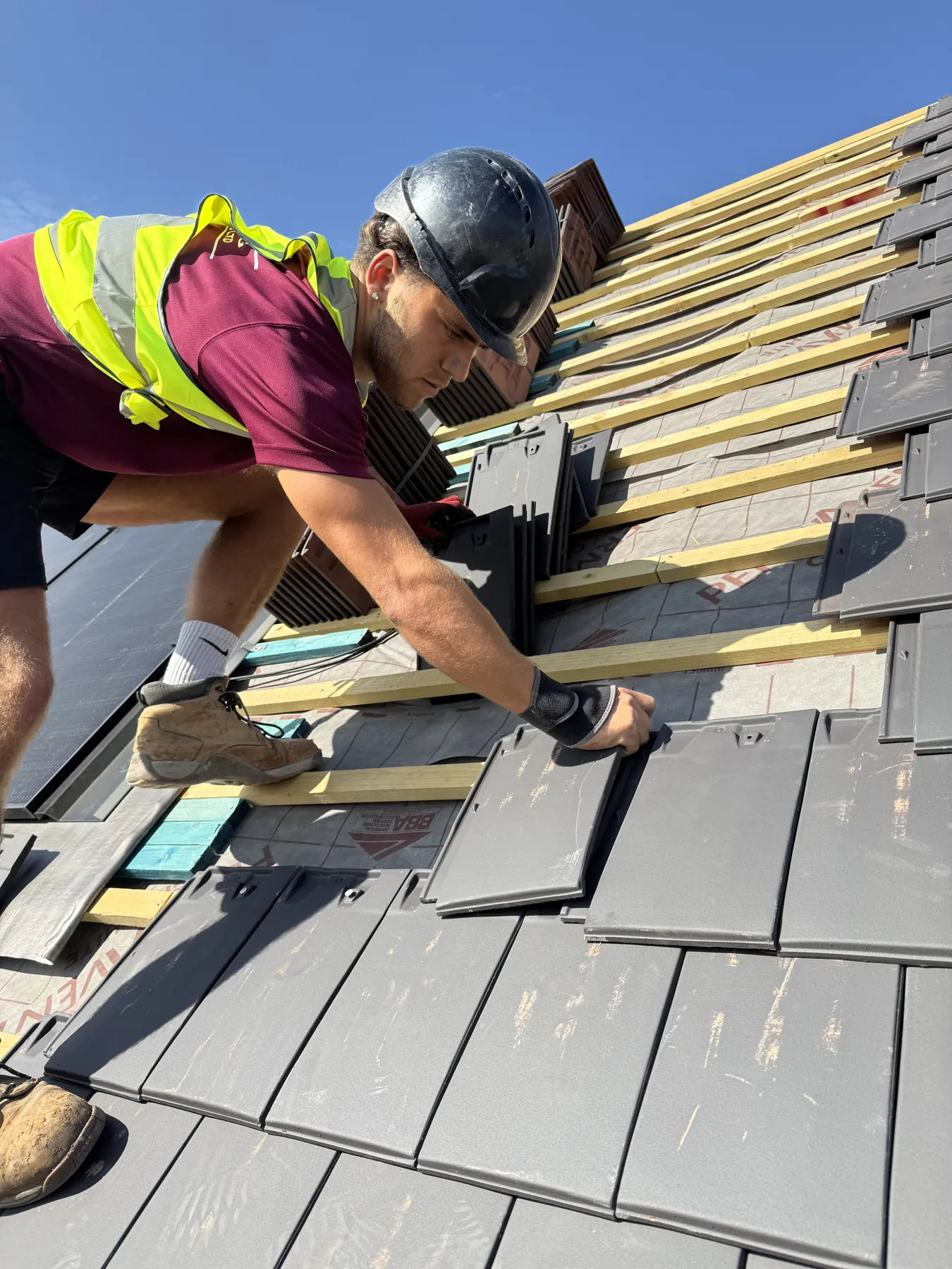 Roofer installing a new slate roof